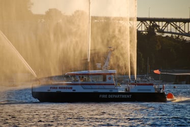 Fireboat in the Ocean with All Hoses Shooting Water to put out a Fire. Preventing fires at marinas, boatyards, and yacht clubs will save lives, property, and loss of community trust. 