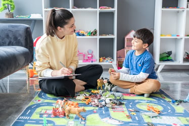 This image shows a Professional Child Psychologist conducting therapy with a neurodivergent child.