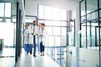 This photo shows a group of doctors walking in a hospital. 