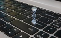 A double helix DNA molecule model placed on top of a laptop keyboard