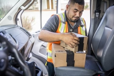 Delivery man taking packages out of car. 