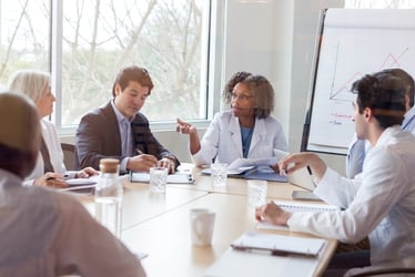 A group of doctors in discussion at a table, representing healthcare auditing 