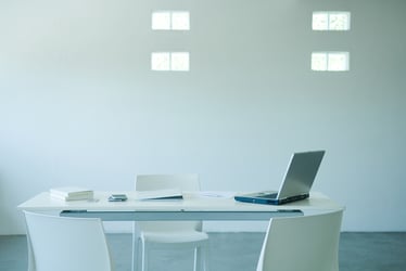 This photo shows an empty desk with computer symbolizing the importance of periodic reviews for retirement plans: stay compliant, fair fees, enhance performance, assess design, address workforce change