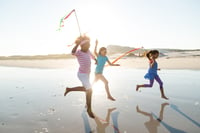 This photo shows children running around on the beach.