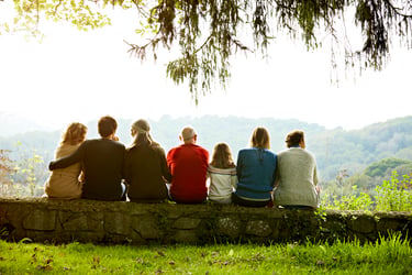 This photo shows seven family members from three generations sitting on a retaining wall on a clear day. Even though you only see their backs, the scene feels tranquil, as if the group is comfortable together. Not all families co-exist this peacefully. A family office works best when family members are aligned on wealth management aspirations, goals, philanthropic philosophy, and appetite for risk.