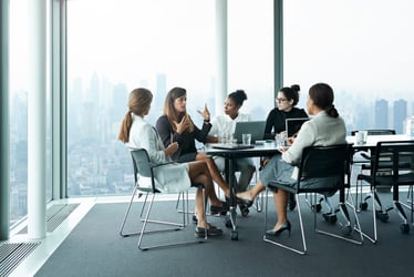 Group of Women Professionals Engaged in Thoughtful Discussion on Women's Health Challenges and Solutions in the Workplace