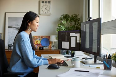 Young female small business woman working at her desk viewing information on her computer.