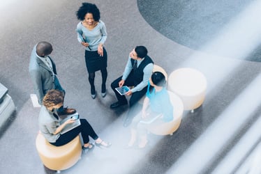 A group of business associates gathered in a conference room discussing Human Capital Management (HCM) topics.