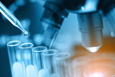 This photo shows a microscope and test tubes representing clinical pipeline insights and expert guidance in pharmacy consulting services