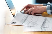 person using laptop to complete financial aid paperwork