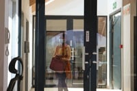 worker wearing a medical face mask entering a building