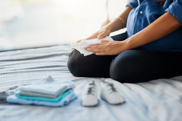 A mother folding laundry, symbolizing the need for parental leave and the impact on work-life balance. Illustration for Risk Strategies' blog on the importance of employee benefits and family building policies.