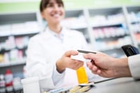 Person paying at pharmacy with HSA card