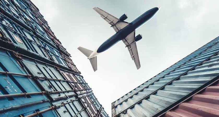 Plane flying over cargo containers