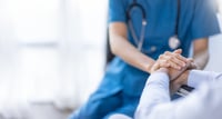 This photo shows a doctor holding hands with their patients  