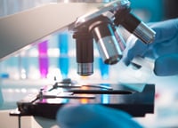 Close-up view of a microscope in a laboratory setting, symbolizing precision and advancement in pharmaceutical research and clinical analysis